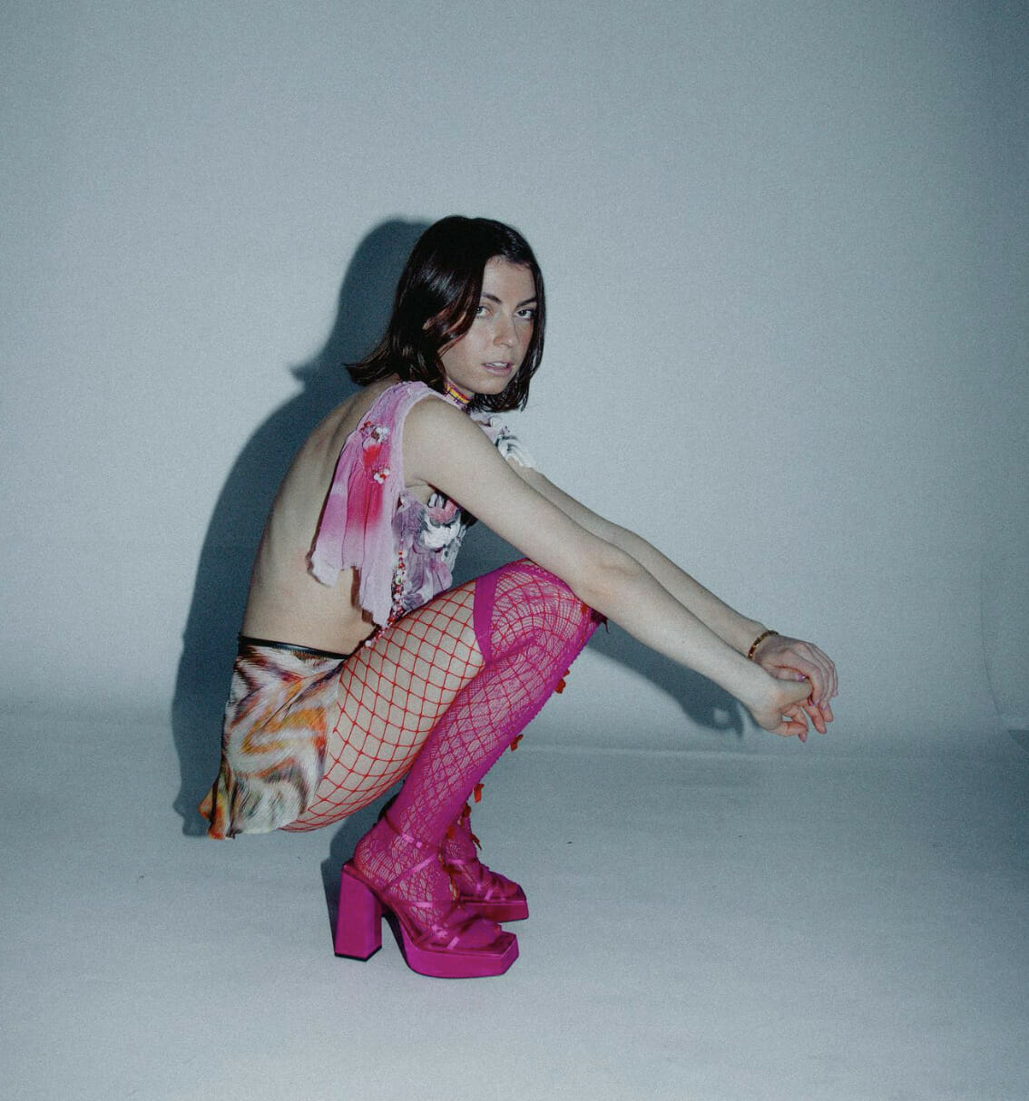 Anna Shoemaker squatting with red fishnets