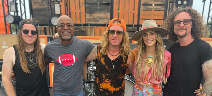 A shot from the set of the music video for "Comin' To Your City," covered by Darius Rucker, Lainey Wilson & The Cadillac Three. The new version will be used as the ESPN College GameDay theme. Retrieved from @thecadillac3 on Instagram.