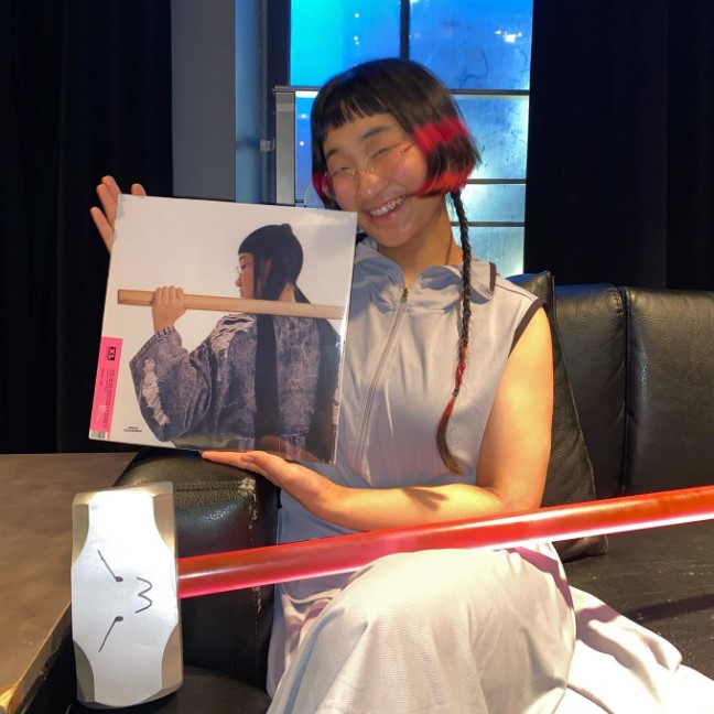 New York by way of Seoul singer & producer Yaeji, posing with a vinyl of her debut album, With A Hammer. Taken from @kraejiyaeji on Instagram.
